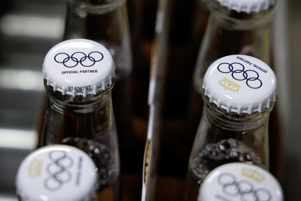 TOPSHOT - This photograph taken on April 23, 2024 shows caps covering beer bottles filled with the Olympics logo on Corona Cero non-alcoholic beer bottles on a production line during a press visit to the Anheuser-Busch InBev (AB InBEV) brewery ) in Leuven.  AB InBev will be a global Olympic partner until 2028. The non-alcoholic beer Corona Cero thus becomes a global sponsor of the Olympic Games.  (Photo by Kenzo TRIBOUILLARD/AFP) (Photo by KENZO TRIBOUILLARD/AFP via Getty Images)