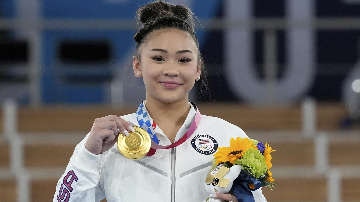 Gold medalist Sunisa Lee of the United States displays her medal for the artistic gymnastics women's all-around at the 2020 Summer Olympics, Thursday, July 29, 2021, in Tokyo. (AP Photo/Gregory Bull)