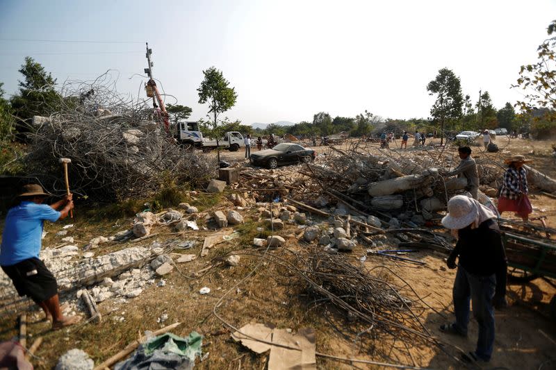 Villagers collect steel at a collapsed building which killed 36 workers in Kep