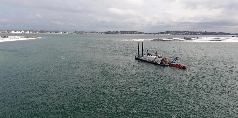 The Barnstable County dredge is stationed at the entrance to Stage Harbor in Chatham, in a view looking east, in 2021. The state last week announced $5.65 million in grants for seven dredging projects in six Cape Cod towns including Chatham.