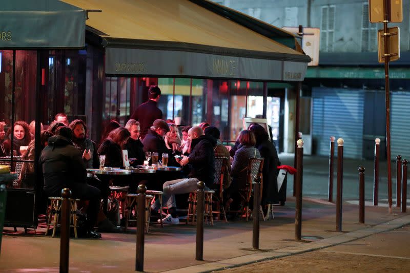 People sit in a outside restaurant, as France's Prime Minister announced to close most all non-indispensable locations, notably cafes, restaurants, cinemas, nightclubs and shops from midnight on Saturday, in Paris