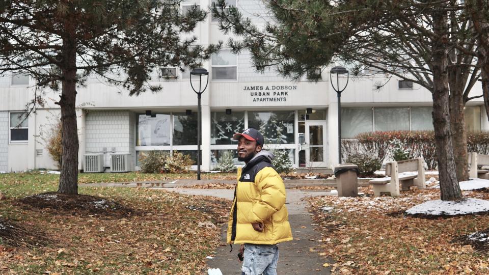 Anthony Miller reminisces in front of the apartment building where he grew up.