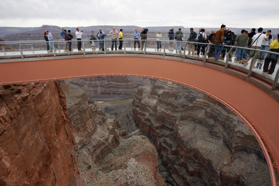 FILE - In this file photo taken Tuesday, March 20, 2007, people walk on the Skywalk during the First Walk event at the Grand Canyon on the Hualapai Indian Reservation at Grand Canyon West, Ariz. The Skywalk opened to the general public on March 28, 2007. A federal court has upheld a $28 million judgment against a business arm of the northern Arizona tribe that owns the Grand Canyon Skywalk. The American Arbitration Association had awarded Las Vegas businessman David Jin the money in August. His attorneys went to federal court to enforce it. Jin invested $30 million to build the Skywalk, a glass bridge that gives visitors a view of the Colorado River from the Hualapai reservation. (AP Photo/Ross D. Franklin, File)