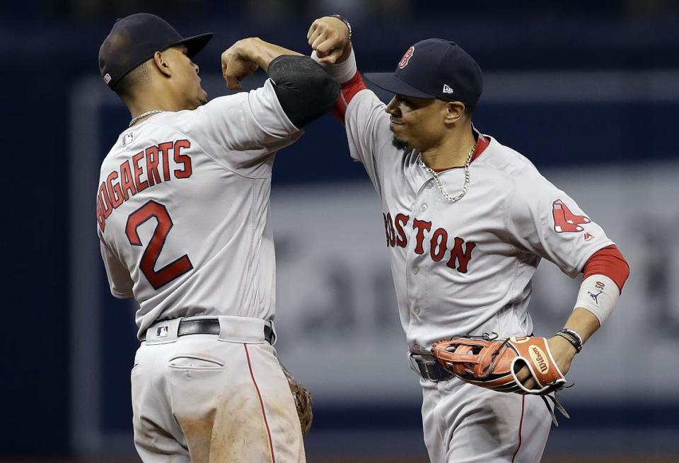 Xander Bogaerts (left) and Mookie Betts celebrate a Red Sox win in Sept. 2017. (AP)