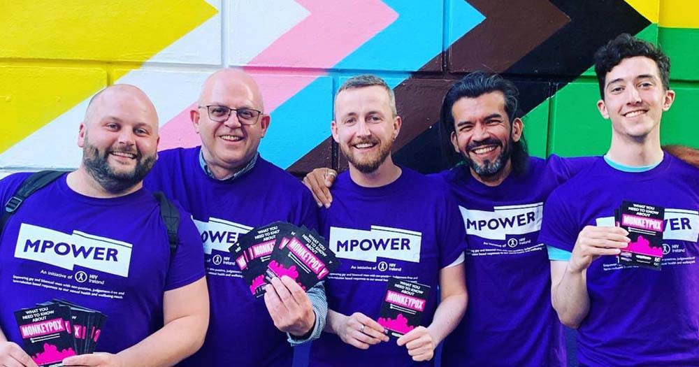 Photo of MPOWER team standing in front of progress Pride flag mural, the MPOX study referenced their work in containing the outbreak