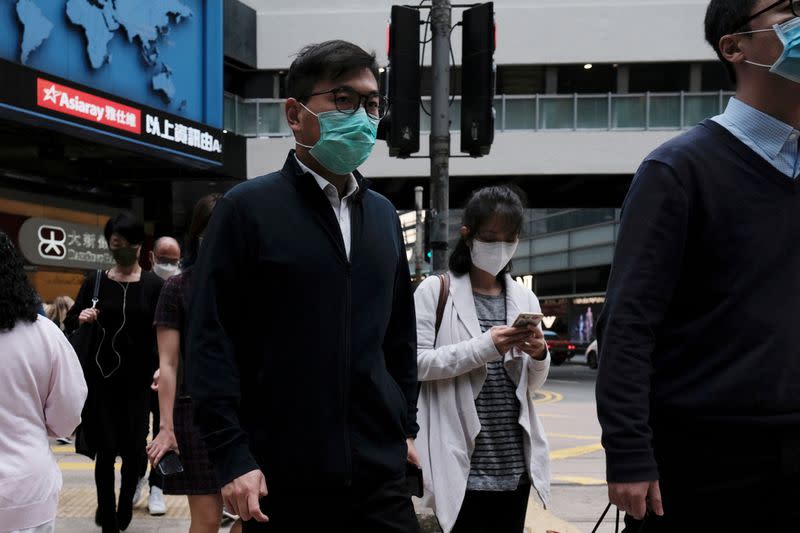 FILE PHOTO: People wear protective face masks as they take their lunch breaks at the financial Central district, following the outbreak of the novel coronavirus, in Hong Kong