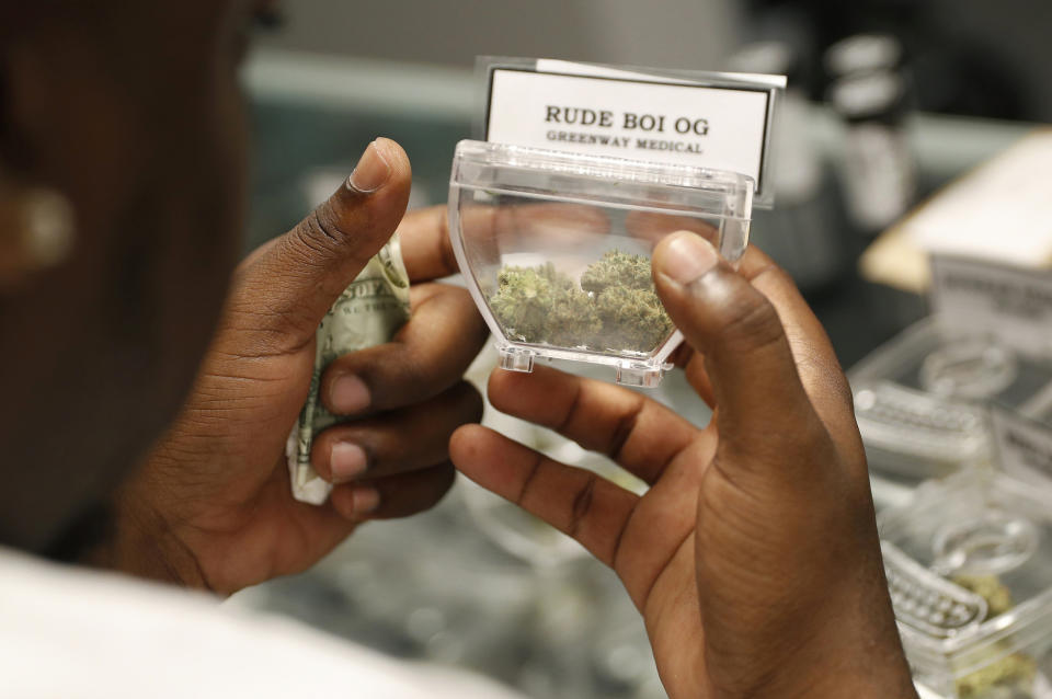 FILE - In this April 20, 2018, file photo, a customer shops for marijuana at the Exhale Nevada dispensary in Las Vegas. A Nevada judge is being asked to freeze the awarding of new dispensary licenses in the state's booming recreational marijuana sales market. Businesses that lost bids for new licenses last year are challenging the criteria and personnel the state used to award the potentially lucrative permits last year. (AP Photo/John Locher, File)