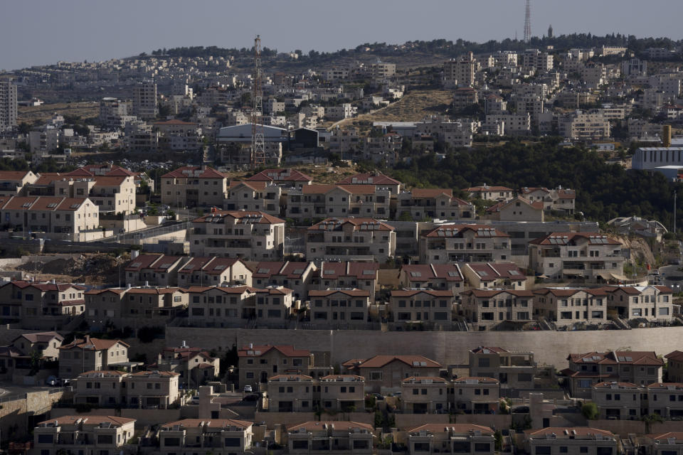 Palestinian buildings are seen behind a section of the West Bank Jewish settlement of Efrat, foreground, Thursday, June 9, 2022. Israeli settlers in the occupied West Bank may soon have a taste of the military rule that Palestinians have been living under for 55 years. A looming end-of-month deadline to extend legal protections to Jewish settlers has put Israel’s government on the brink of collapse and drawn widespread warnings that the territory could be plunged into chaos. (AP Photo/Maya Alleruzzo)