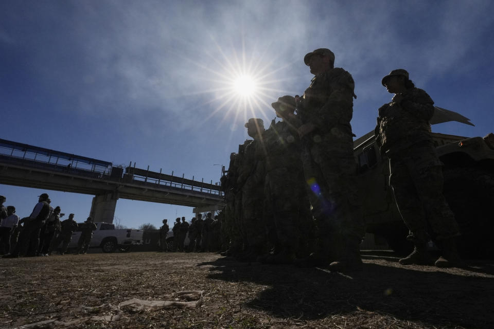 Members of the National Guard stand as Texas Gov. Greg Abbott and fellow governors hold a news conference along the Rio Grande to discuss Operation Lone Star and border concerns, Sunday, Feb. 4, 2024, in Eagle Pass, Texas. Abbott returned to the Eagle Pass border to highlight his escalating attempts to curb illegal crossings on the U.S.-Mexico border. He was joined Sunday afternoon by more than a dozen other GOP governors, all of whom have cheered on his extraordinary showdown with the Biden administration over immigration enforcement. (AP Photo/Eric Gay)