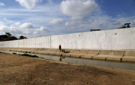 FILE PHOTO: Ecuadorean workers build a wall along the border between Peru and Ecuador in Aguas Verdes, Peru, June 8, 2017. REUTERS/ Nestor Quinones/File Photo