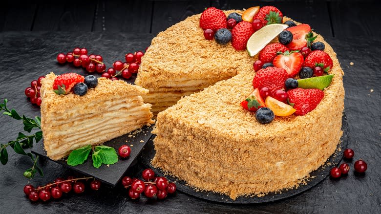 Crepe cake covered in crumbs and topped with fruits