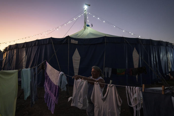 Timoteo Circus performer Arturo Peña, 66, hangs his wash on a makeshift clothesline, on the outskirts of Santiago, Chile, Saturday, Dec. 10, 2022. Peña, whose transformations includes “La loca de la cartera" or “The Crazy Purse Lady,” a role that has allowed him to escape life in the countryside and give life to his artistic side, which he combines with an administrative weekday job. (AP Photo/Esteban Felix)