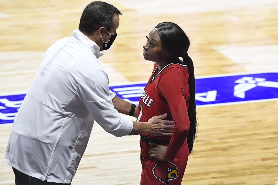 FILE - In this Dec. 4, 2020, file photo, Louisville head coach Jeff Walz, left, speaks with Louisville's Dana Evans during the second half of an NCAA college basketball game against DePaul in Uncasville, Conn. Louisville coach Jeff Walz first heard his 5-year-old daughter sing the national anthem while she was in the playroom this week. He was blown away. So was his team after it heard a recorded rendition of Lucy singing “The Star-Spangled Banner” on Thursday night before the Senior Night game against Georgia Tech. (AP Photo/Jessica Hill, File)