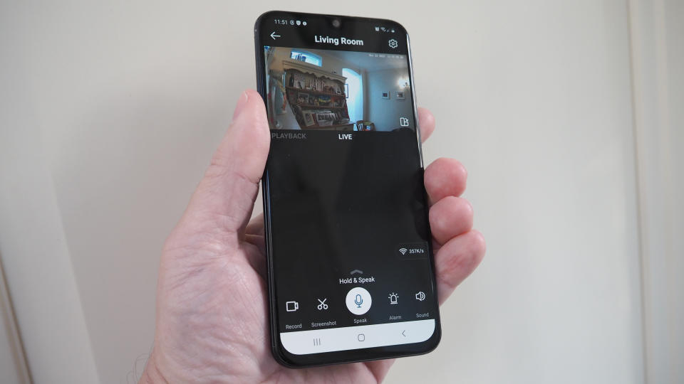 Phone held in a hand showing the app for a Eufy Indoor Cam C120