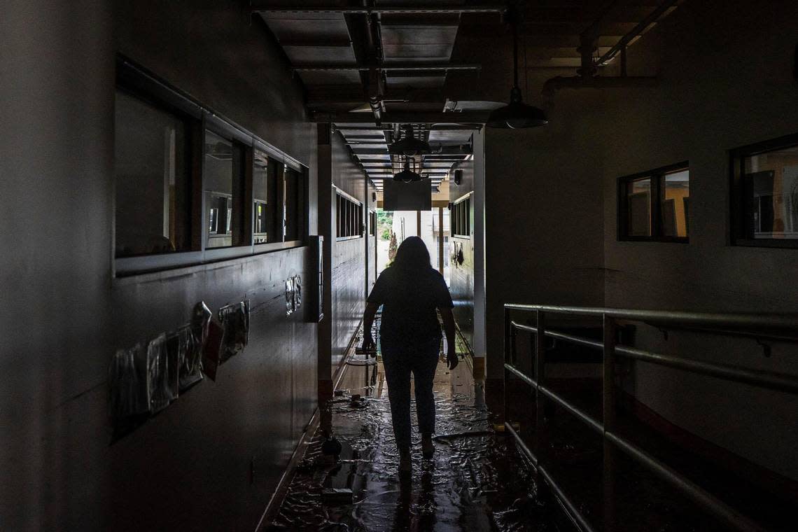 Renee Anderson, Appalachian Artisan Center artistic director, walks through the building Thursday, July 28, 2022, after it was damaged by flood waters that swept through Hindman, Ky., early in the morning. (Ryan C. Hermens/Lexington Herald-Leader via AP)