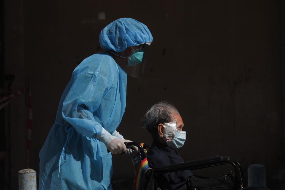 A resident of the nursing home "The Salvation Army Lung Hang Residence for Senior Citizens" is evacuated by medical staff from the Centre for Health Protection, after employees of the nursing home were found to have the coronavirus COVID-19, in Hong Kong, Friday, July 24, 2020. Hong Kong is facing a "critical stage" in its fight against COVID-19, and the government is extending anti-virus measures, Health Secretary Sophia Chan said Wednesday. (AP Photo/Kin Cheung)