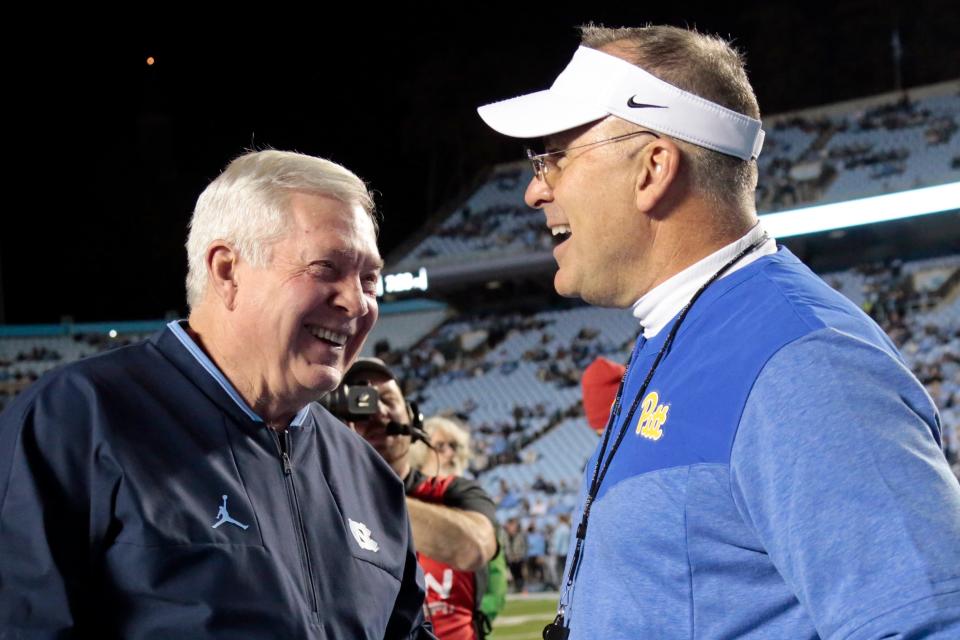 North Carolina head coach Mack Brown, left, and Pittsburgh head coach Pat Narduzzi, right, laugh as they chat before the start of an NCAA college football game in Chapel Hill, North Carolina, on Oct. 29.