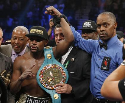 Floyd Mayweather (L) poses with referee Kenny Bayless after his win over Manny Pacquiao. (AP)