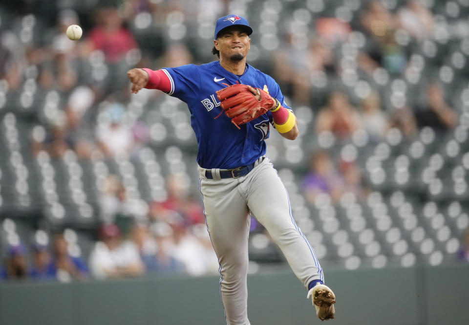 Toronto Blue Jays third baseman Santiago Espinal throws to first base to put out Colorado Rockies' Brenton Doyle in the eighth inning of a baseball game Sunday, Sept. 3, 2023, in Denver. (AP Photo/David Zalubowski)