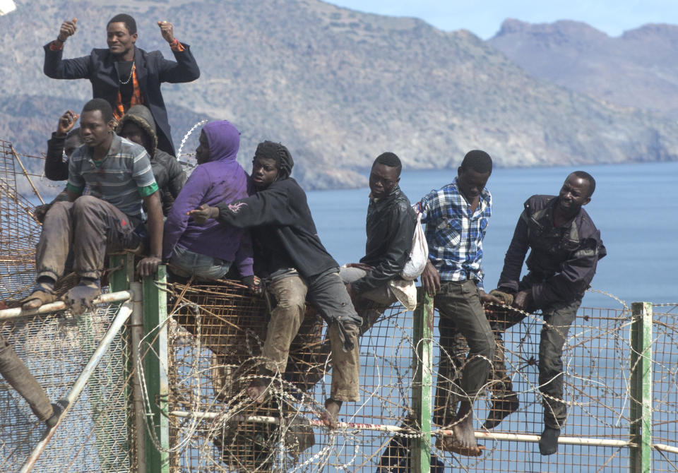 Sub-Saharan migrants sit on top of a metallic fence that divides Morocco and the Spanish enclave of Melilla on Thursday, April 3, 2014. Spanish and Moroccan police have thwarted a fresh attempt by dozens of African migrants to try to scale border fences to enter the Spanish enclave of Melilla. Thousands of sub-Saharan migrants seeking a better life in Europe are living illegally in Morocco and regularly try to enter Melilla in the hope of later making it to mainland Spain. (AP Photo/Santi Palacios)