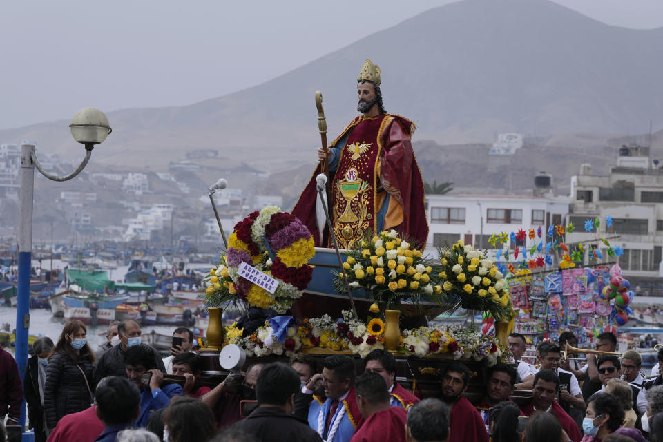 Pescadores cargan una estatua de San Pedro, el patrón católico de los pescadores, mientras realizan una procesión por tierra y mar para conmemorar su fiesta en Pucusana, Perú, el miércoles 29 de junio de 2022. (Foto AP/Martín Mejia)