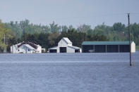 In this May 10, 2019 photo, farm buildings belonging to Brett Adams are surrounded by flood waters, in Peru, Neb. Adams had thousands of acres under water, about 80 percent of his land, this year. It split open his grain bins and submerged his parents' house and other buildings when the levee protecting the farm broke. (AP Photo/Nati Harnik)