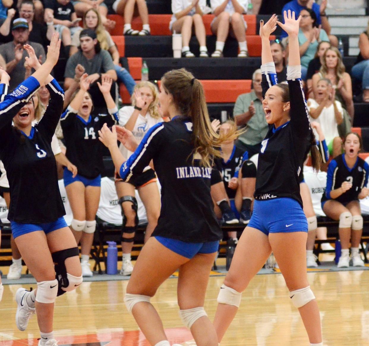 Inland Lakes volleyball players celebrate a point during Tuesday night's matchup at Harbor Springs.