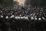 Police officers block the way of the supporters of Tehreek-e-Labiak Pakistan, a radical Islamist political party, marching toward Islamabad, in Lahore, Pakistan, Friday, Oct. 22, 2021. Thousands of Islamists launched their "long march" from the eastern city of Lahore toward Pakistan's capital, demanding that the government release the leader of their Saad Rizvi, who was arrested last year amid demonstrations against France over publishing caricatures of Islam's Prophet Muhammad. (AP Photo/K.M. Chaudary)