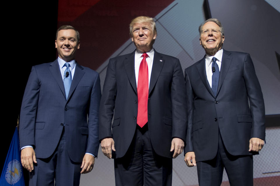 President Donald Trump (center) stands beside NRA CEO and executive vice president Wayne LaPierre (right)&nbsp;and&nbsp;NRA-ILA executive director Chris Cox (left). The NRA donated over $30 million to Trump's presidential campaign in 2016. (Photo: JIM WATSON via Getty Images)