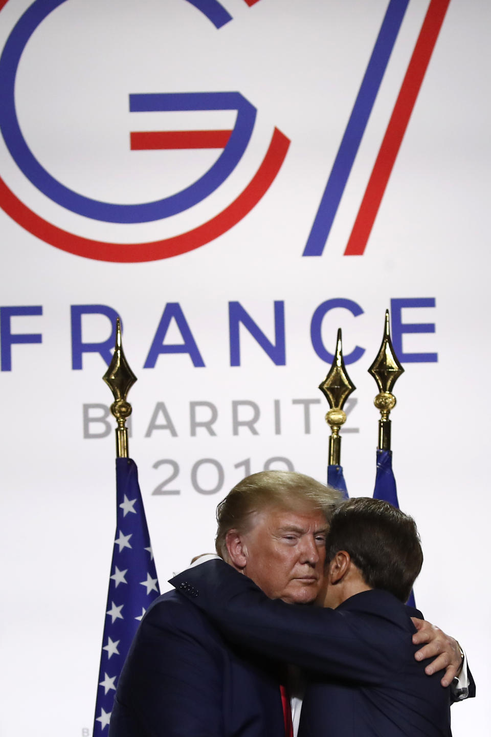 U.S President Donald Trump and French President Emmanuel Macron hug after their joint press conference at the G7 summit Monday, Aug. 26, 2019 in Biarritz, southwestern France. French president says he hopes for meeting between US President Trump and Iranian President Rouhani in coming weeks. (AP Photo/Francois Mori)