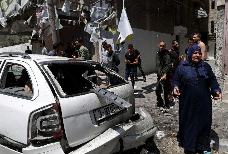 Image: Residents gather around a car that was hit in an Israeli airstrike that killed three people in the car, on the main road in Gaza City (Adel Hana / AP)