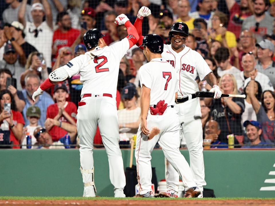 Boston Red Sox designated hitter Justin Turner (2) celebrates with left fielder Masataka Yoshida (7) and third baseman Rafael Devers (11) after hitting a two-run home run against the New York Mets during the seventh inning on July 22, 2023, at Fenway Park.