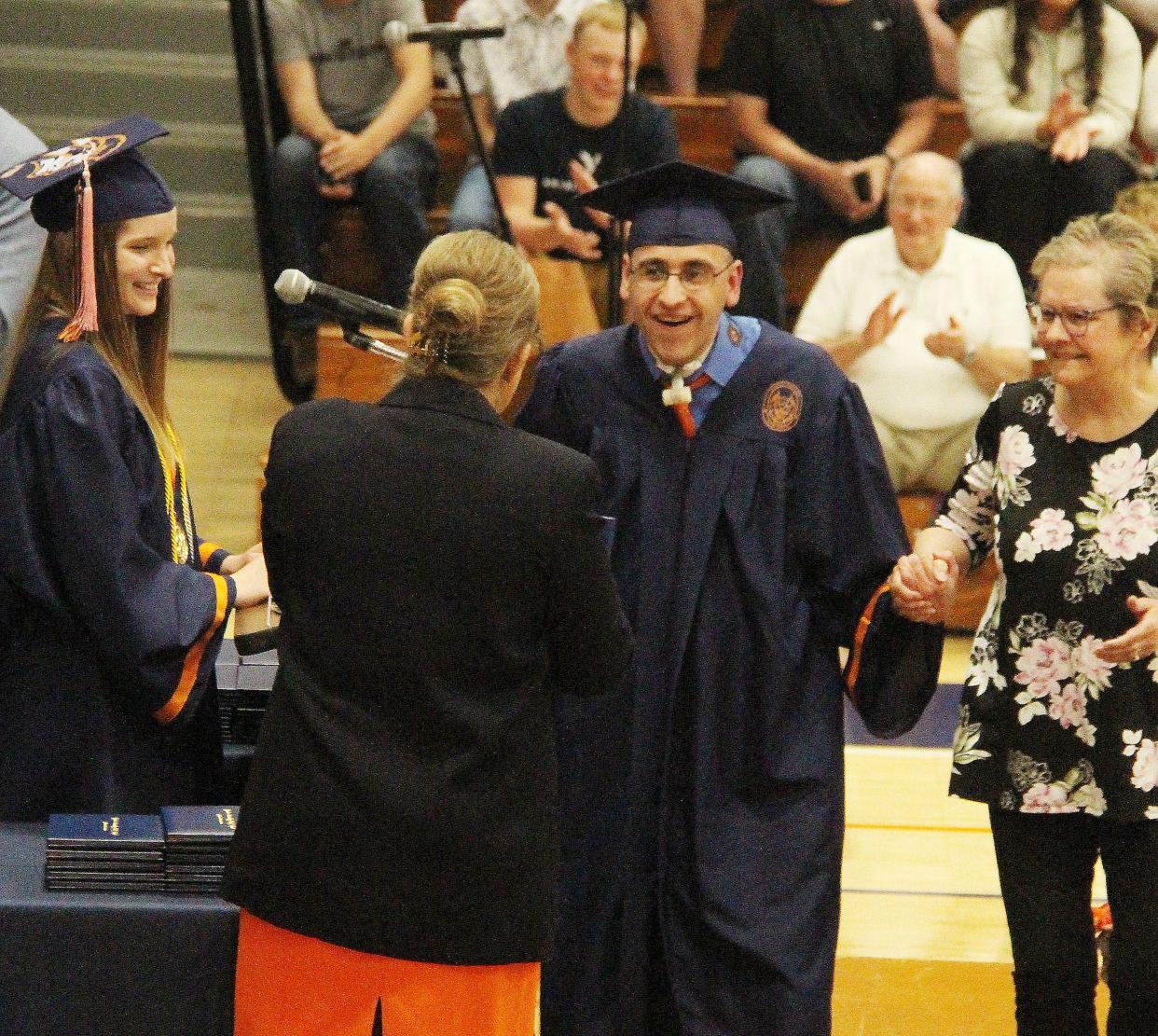Sergio Gonzalez is all smiles as he receives his diploma from Pontiac Township High School District 90 board member Mary Brainard during graduation ceremonies Sunday at PTHS.
