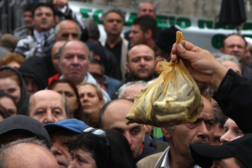 Greek farmers' market vendors distribute free produce as part of a protest in the northern Greek city of Thessaloniki, Wednesday, April 30, 2014, after their trading association launched an indefinite strike Monday. The market vendors are the latest professional group in Greece to protest a sweeping liberalization drive demanded by rescue creditors. (AP Photo/Nikolas Giakoumidis)