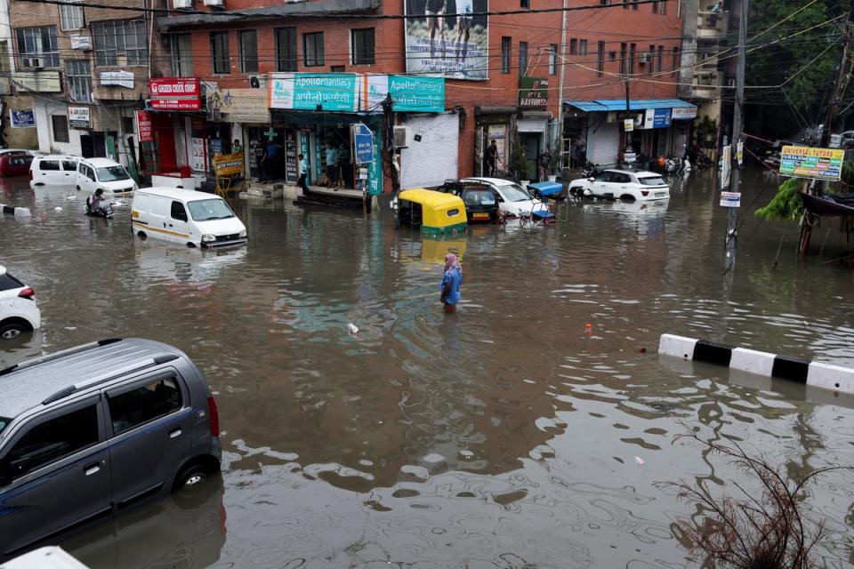 A person wades through a flooded street after heavy rains in New Delhi (REUTERS)