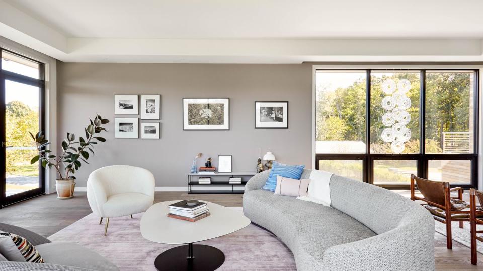 a living room with a large window and curved sofa