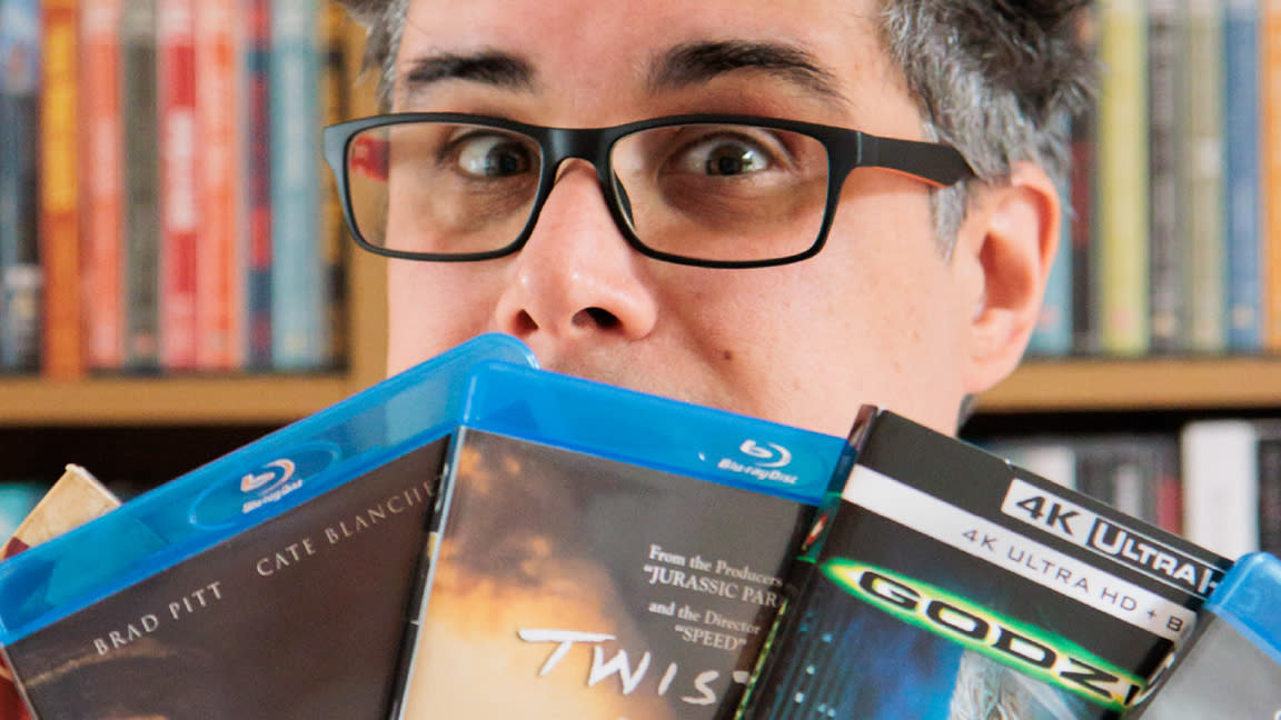  CGI in movies; a man looks over the top of a selection of Blu-ray cases  