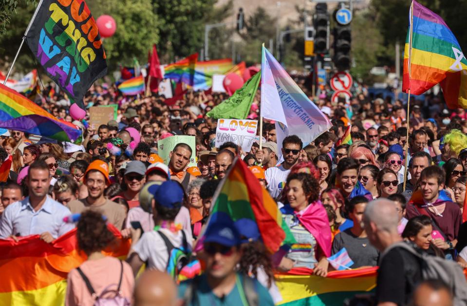 Participants wave banners and LGBTQ rainbow flags during the annual Pride parade, as Israel lifted COVID-19 restrictions, in Jerusalem on June 3, 2021. 