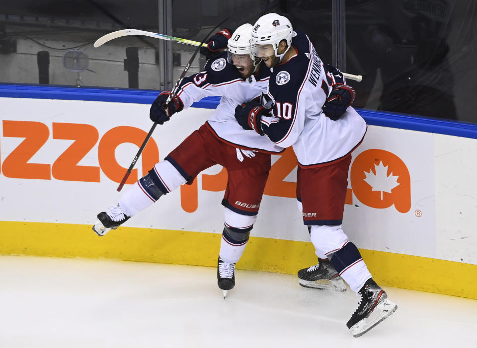 Columbus Blue Jackets right wing Cam Atkinson (13) celebrates his goal against the Toronto Maple Leafs with Alexander Wennberg (10) during the third period of an NHL hockey playoff game in Toronto, Sunday, Aug. 2, 2020. (Nathan Denette/The Canadian Press via AP)