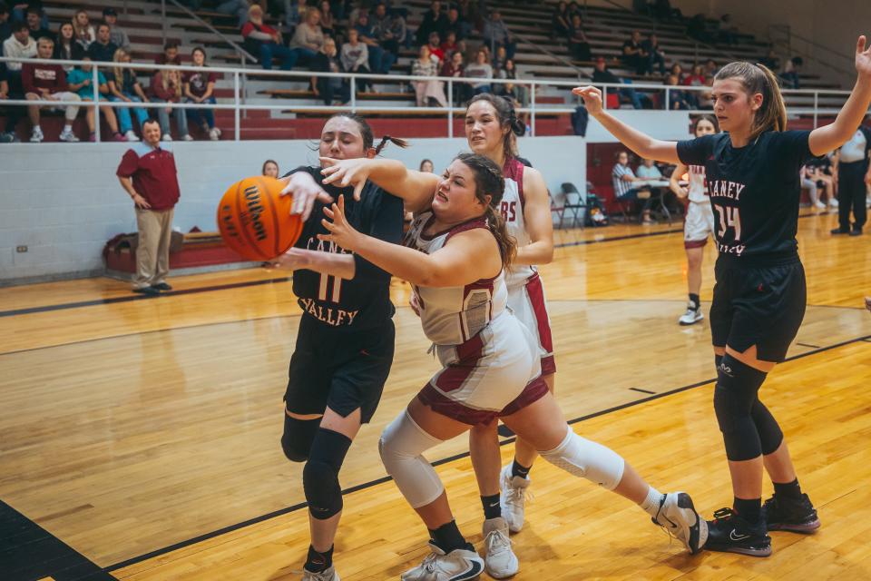 Caney Valley's Jill Emery, No. 11, and a Barnsdall player fight for possession of the ball during a game at Barnsdall.