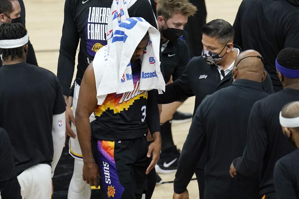 An injured Phoenix Suns guard Chris Paul (3) walks off the court during the first half of Game 1 of their NBA basketball first-round playoff series against the Los Angeles Lakers Sunday, May 23, 2021, in Phoenix. (AP Photo/Ross D. Franklin)