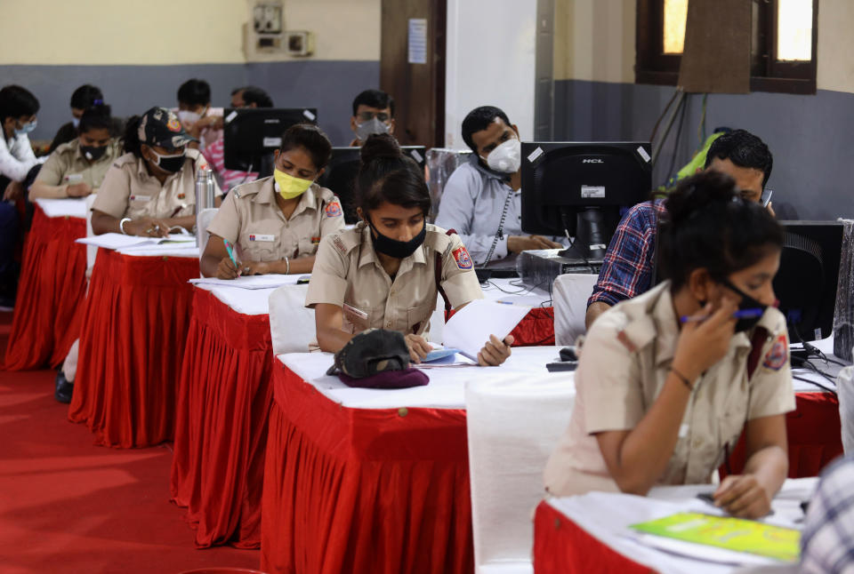 Indian volunteers from Delhi Civil Defence (DCD) wearing face masks work at the COVID-19 District Central Surveillance and Tele-medicine Hub to serve as a free help line service for the COVID-19 patients and their families.The Doctors and Counsellors update data, register all grievances, daily health status of COVID-19 patients and prevent them from getting critical, provide Medical help, sanitation and removal of biomedical waste and provide them with essential commodities. This was launched at the office of the District Magistrate of the central district at Daryaganj. (Photo by Naveen Sharma/SOPA Images/LightRocket via Getty Images)