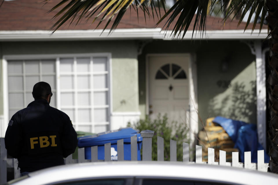A FBI agent stands outside of a home while it was being search in connection with a a cold case Wednesday, Feb. 5, 2020, in Los Angeles. Search warrants were served Wednesday at locations in California and Washington state in the investigation of the disappearance of Kristin Smart, the California Polytechnic State University, San Luis Obispo student who disappeared in 1996. (AP Photo/Marcio Jose Sanchez)