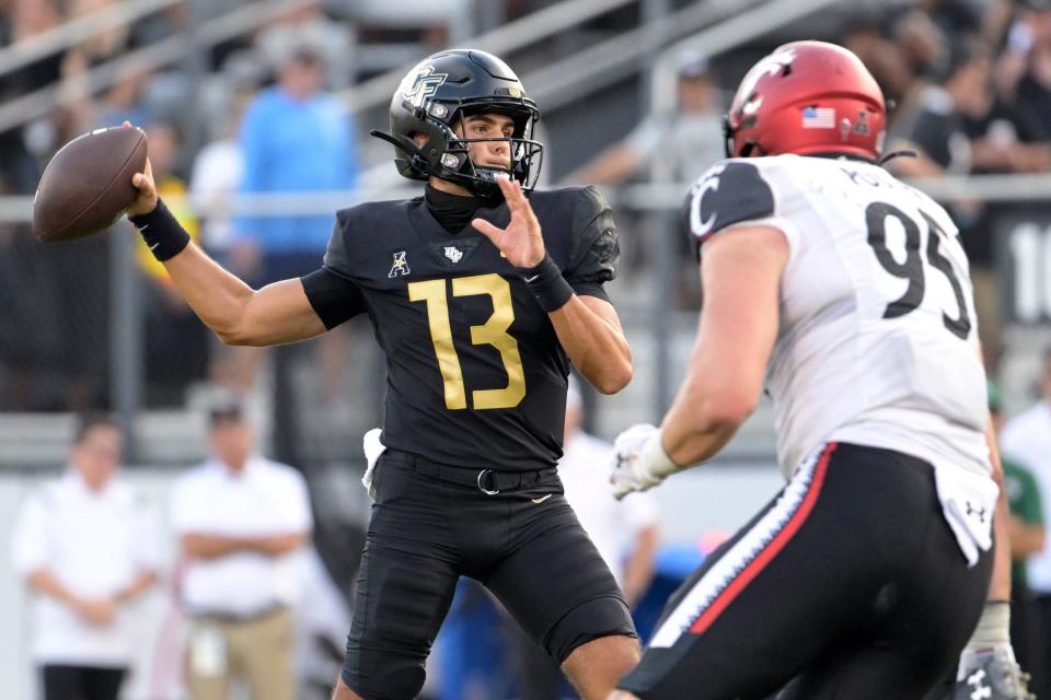 Central Florida quarterback Mikey Keene (13) looks to throw a pass in front of Cincinnati defensive lineman Noah Potter (95) during the second half of an NCAA college football game, Saturday, Oct. 29, 2022, in Orlando, Fla. (AP Photo/Phelan M. Ebenhack)