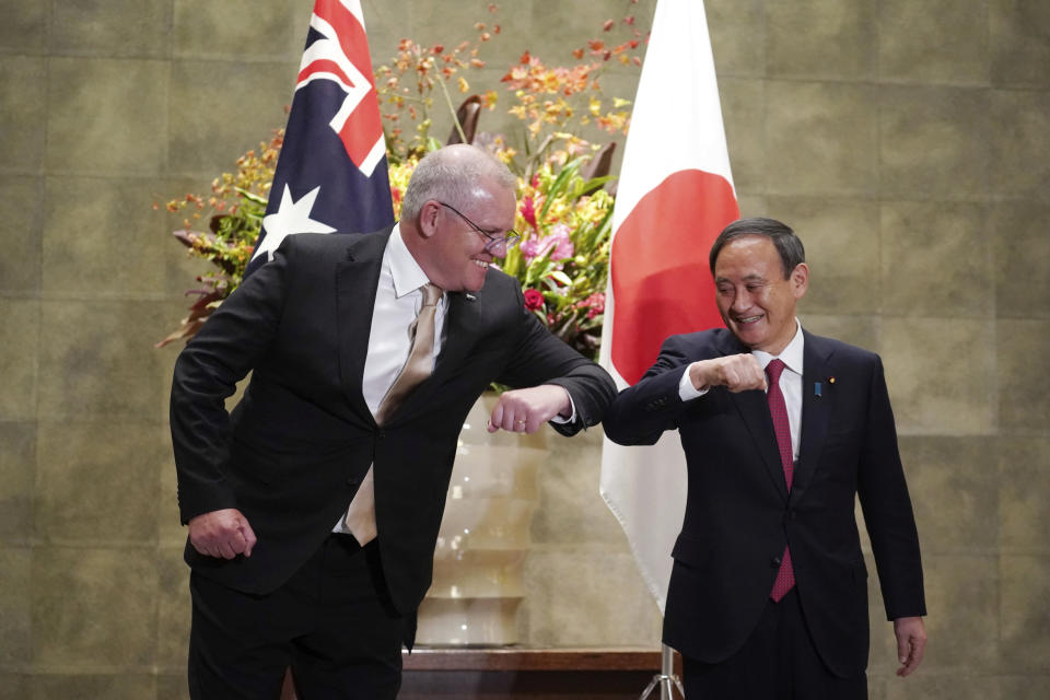 Australian Prime Minister Scott Morrison, left, and Japanese Prime Minister Yoshihide Suga bump elbows to greet prior to the official welcome ceremony at Suga's official residence in Tokyo Tuesday, Nov. 17, 2020. Morrison is in Japan to hold talks with Suga to bolster defense ties between the two U.S. allies to counter China’s growing assertiveness in the Asia-Pacific region. (AP Photo/Eugene Hoshiko, Pool)