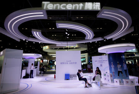 FILE PHOTO: People use smartphones at a Tencent booth during the Global Mobile Internet Conference (GMIC) 2017 in Beijing, China April 28, 2017. REUTERS/Jason Lee/File Photo