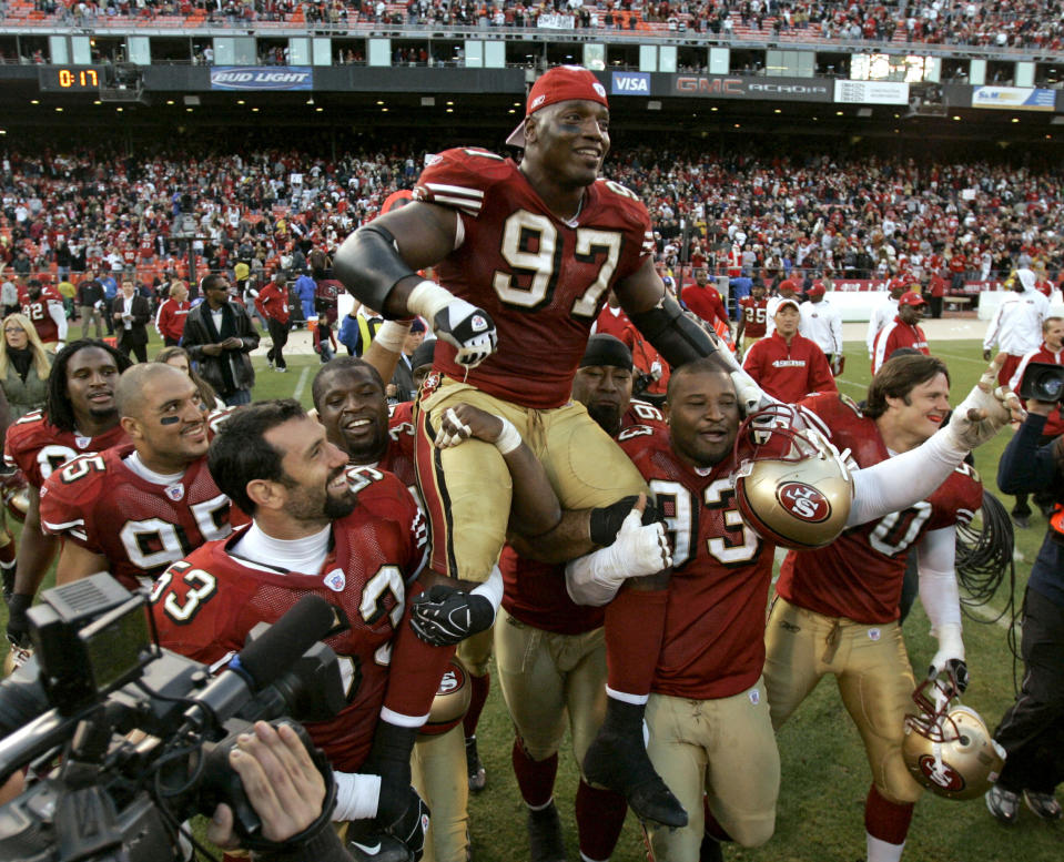 FILE - San Francisco 49ers defensive end Bryant Young (97) is carried off the field by teammates after his team's win over the Tampa Bay Buccaneers in an NFL football game in San Francisco, on Dec. 23, 2007. Young's ability to inspire — both through his play and through his response to unimaginable setbacks on and off the field — finally earned him admission to the Pro Football Hall of Fame this summer, nearly 15 years after his last game. (AP Photo/Marcio Jose Sanchez, File)