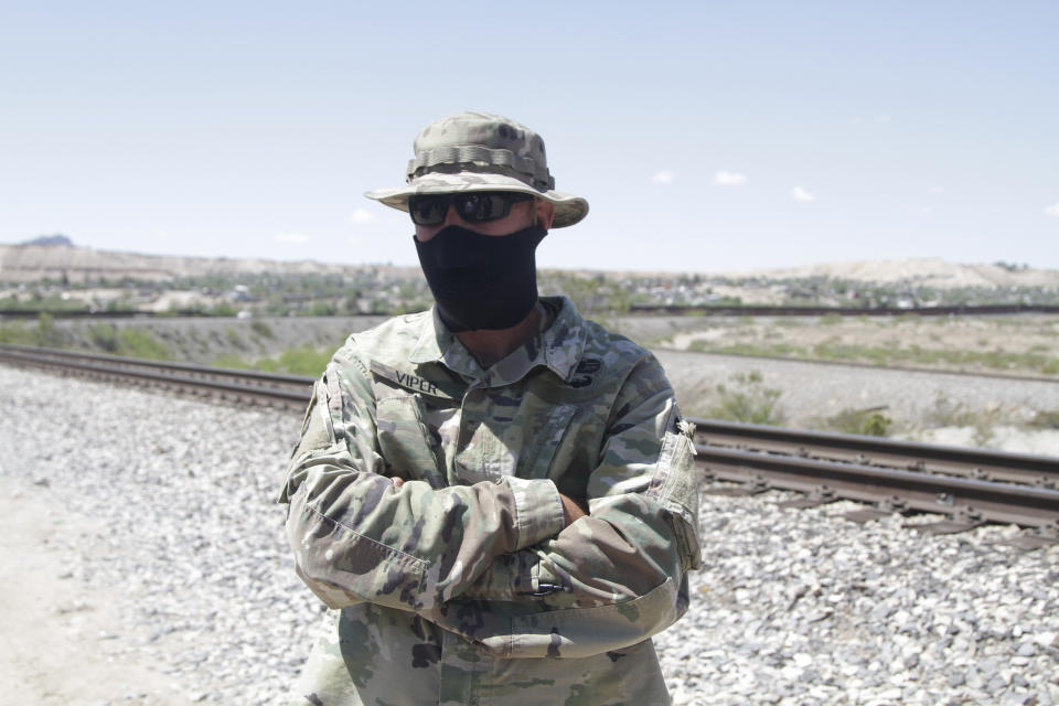 An self-styled Patriot stands a quarter mile from a barrier that marks the U.S.-Mexico border Tuesday, April 23, 2019, in Sunland Park, N.M., hours before being removed from his group's campsite by police. Members of the United Constitutional Patriots gained national attention after filming themselves detaining immigrants who cross the border to the east where the wall ends. (AP Photo/Cedar Attanasio)