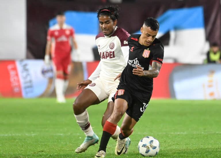 Tiago Palacios controla frente a Raúl Loaiza; el uruguayo no gravitó en la ofensiva de Estudiantes y el colombiano fue expulsado en Lanús y perdió la marca en uno de los goles pincharratas.