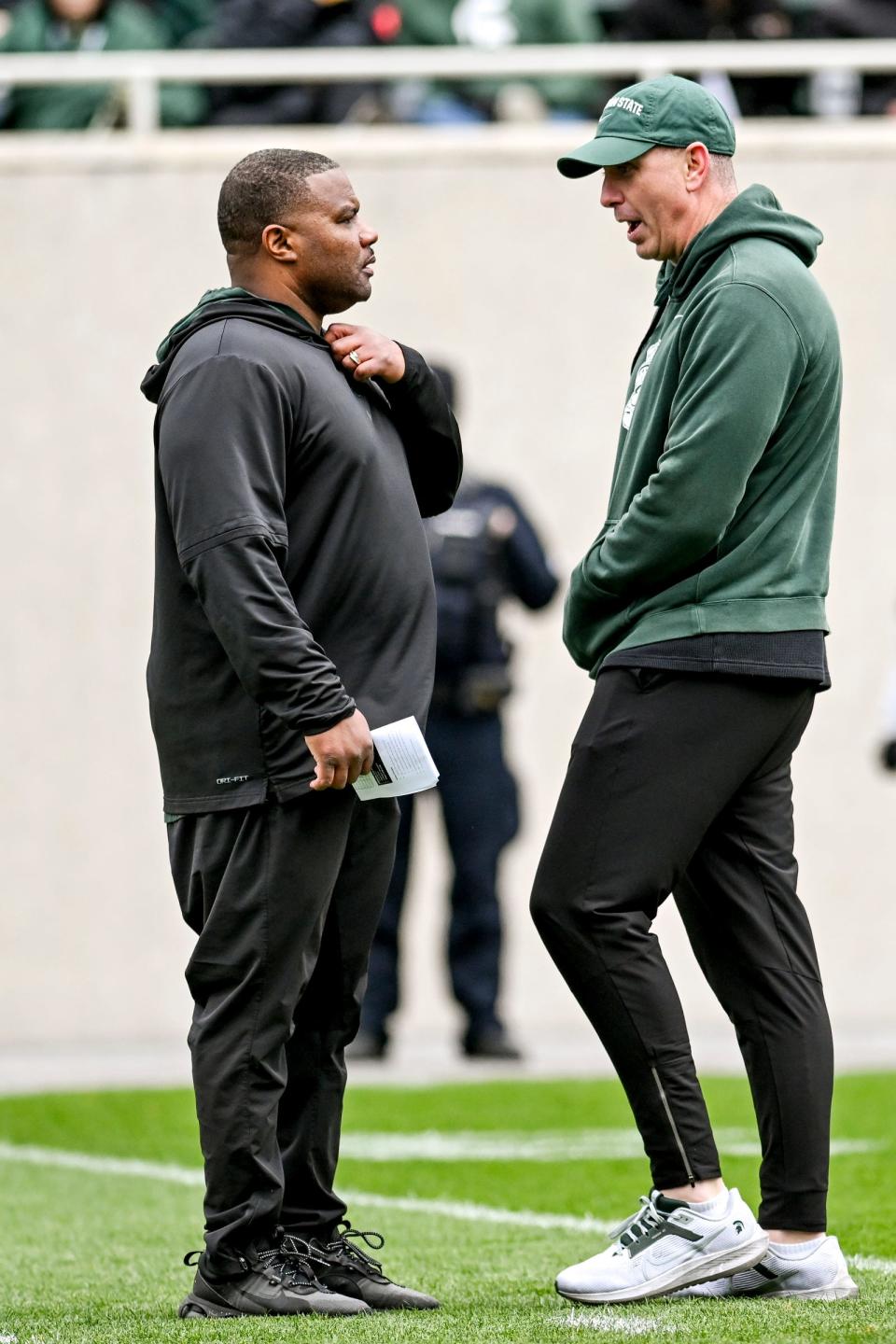 Michigan State assistant head coach Keith Bhonapha, left, talks with offensive coordinator Brian Lindgren during the Spring Showcase on Saturday, April 20, 2024, at Spartan Stadium in East Lansing.